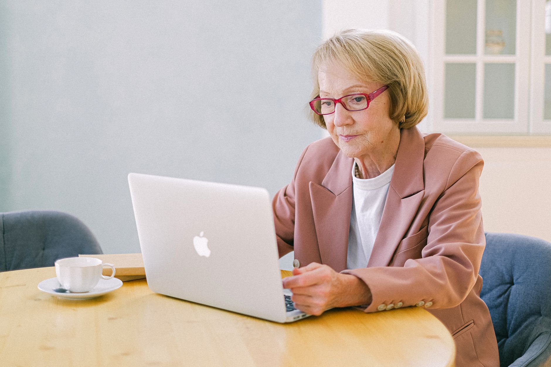 Older adult using a laptop at a table